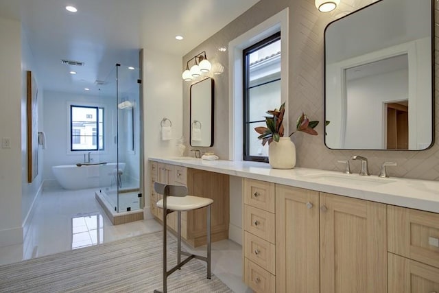 bathroom with vanity, backsplash, and shower with separate bathtub