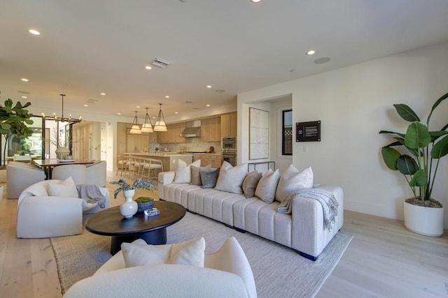 living room featuring light hardwood / wood-style flooring and a notable chandelier