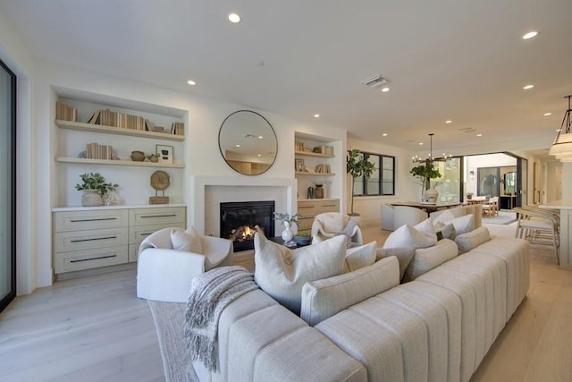 living room with built in features and light hardwood / wood-style flooring