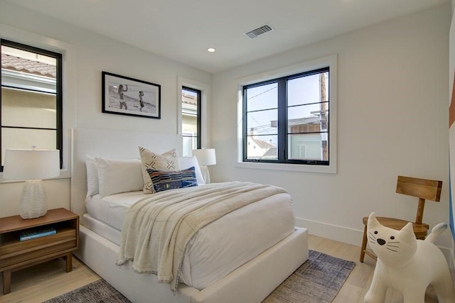 bedroom featuring light hardwood / wood-style flooring and multiple windows