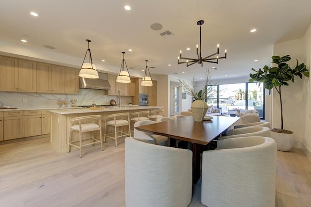 dining space featuring a notable chandelier and light hardwood / wood-style flooring