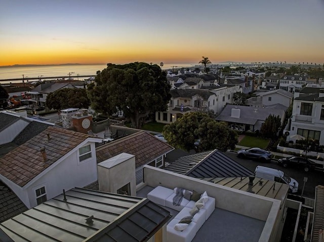 aerial view at dusk featuring a water view