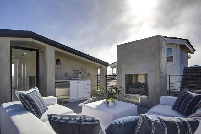 view of patio featuring an outdoor living space with a fireplace