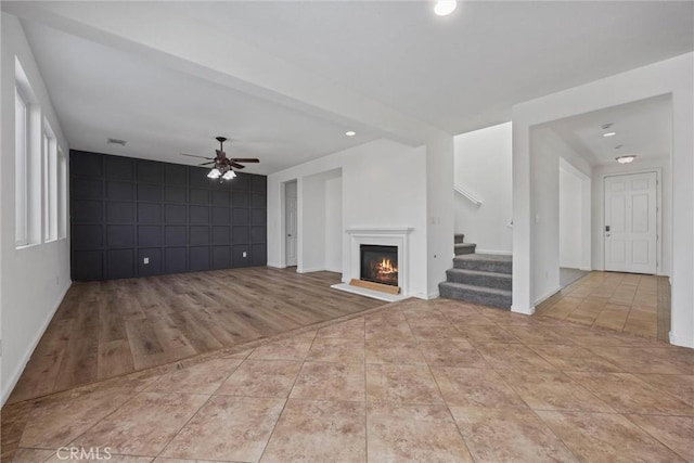 unfurnished living room with ceiling fan and light wood-type flooring