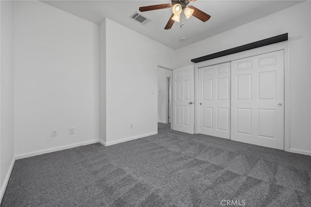 unfurnished bedroom with ceiling fan, a closet, and dark carpet