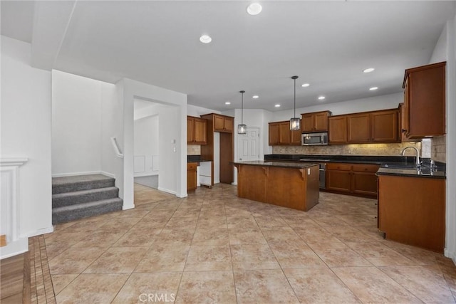 kitchen with tasteful backsplash, sink, light tile patterned floors, a kitchen island, and hanging light fixtures