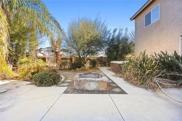 view of yard with a patio and an outdoor fire pit