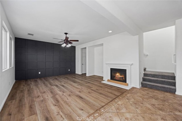 unfurnished living room featuring ceiling fan and light wood-type flooring