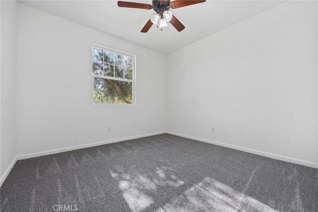 spare room featuring ceiling fan and dark carpet