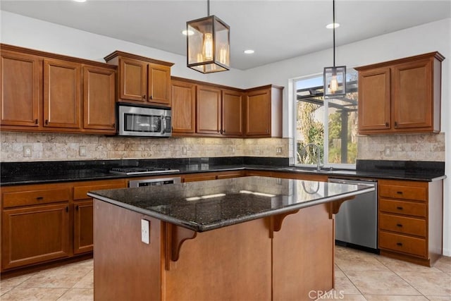 kitchen featuring a center island, dark stone counters, hanging light fixtures, a breakfast bar area, and stainless steel appliances