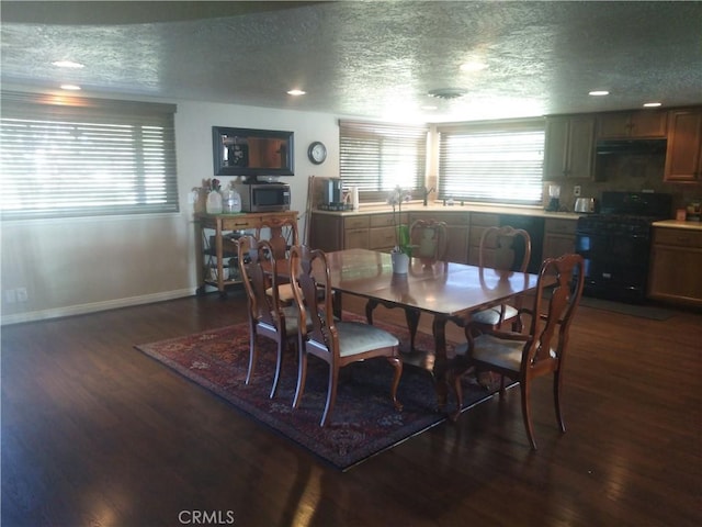 dining space with dark hardwood / wood-style floors and a textured ceiling