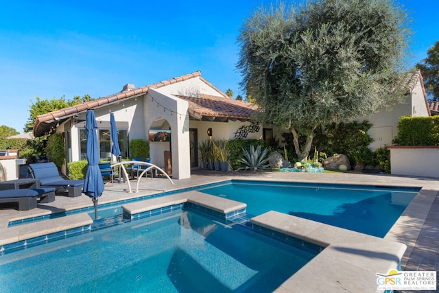 view of pool with an in ground hot tub and a patio