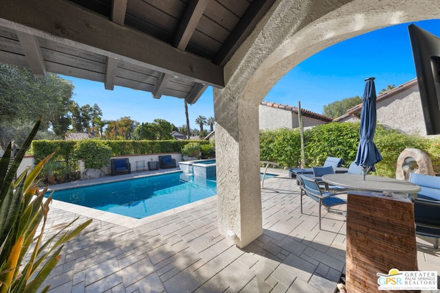 view of swimming pool with an in ground hot tub and a patio area