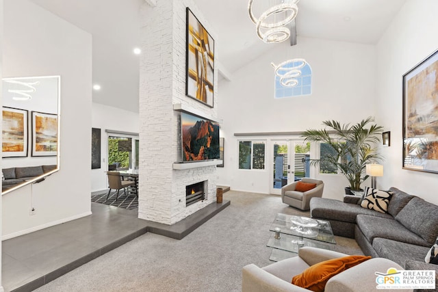 carpeted living room with a chandelier, high vaulted ceiling, and a healthy amount of sunlight