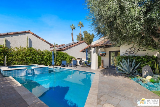 view of swimming pool with a patio area and an in ground hot tub