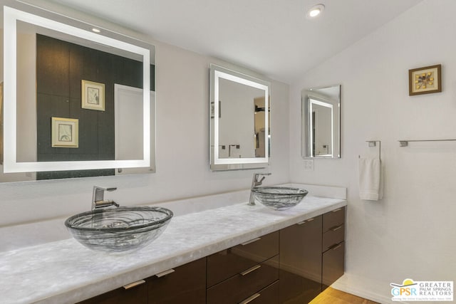 bathroom with vanity and lofted ceiling