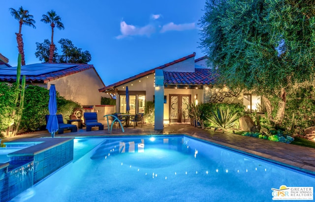 view of pool with french doors and a patio area