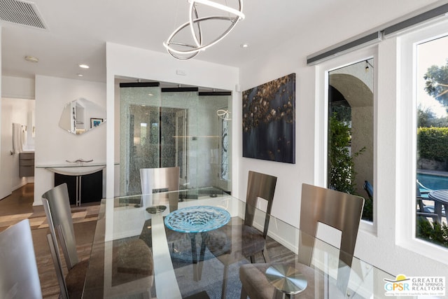 dining area with wood-type flooring and a chandelier