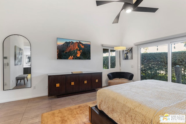 tiled bedroom featuring ceiling fan and a towering ceiling