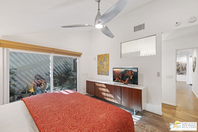 bedroom featuring ceiling fan, hardwood / wood-style floors, and high vaulted ceiling