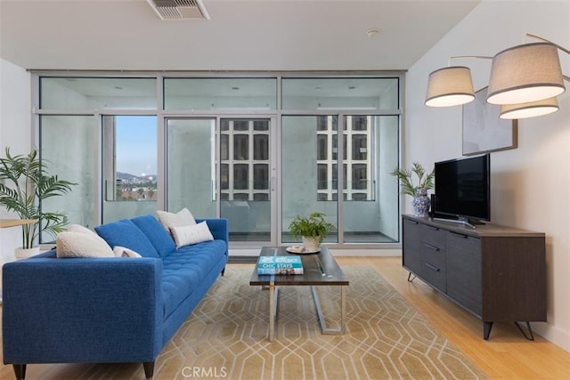 living room featuring light wood-type flooring and expansive windows