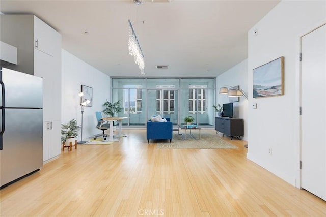 interior space featuring light wood-type flooring and a wall of windows