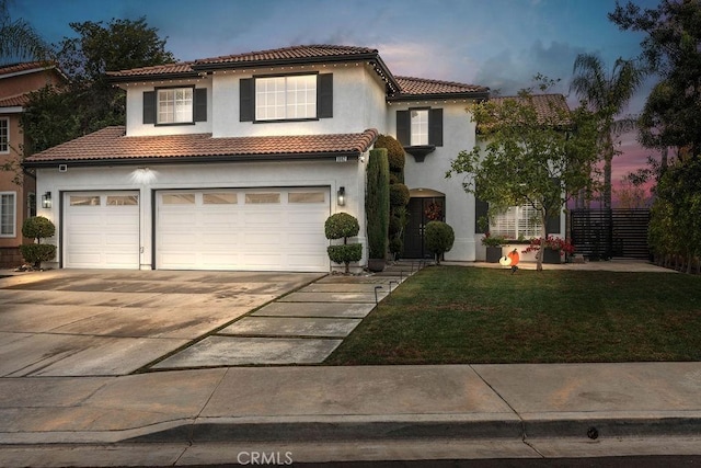 mediterranean / spanish-style house featuring a lawn and a garage