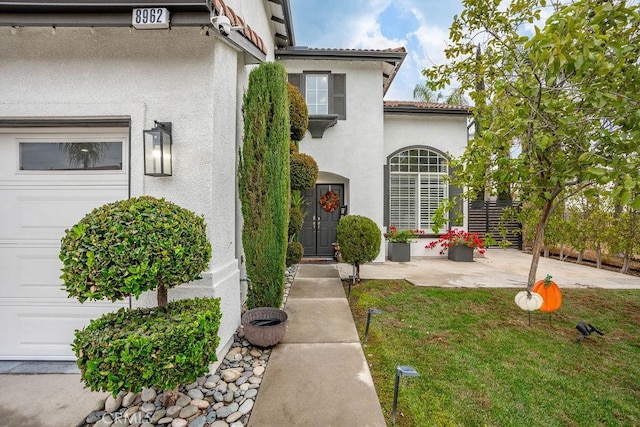 doorway to property featuring a lawn