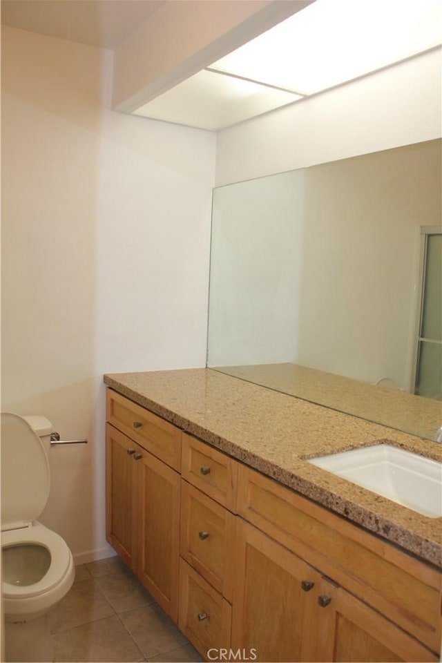 bathroom featuring tile patterned flooring, vanity, and toilet