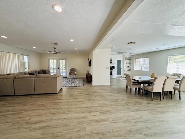 dining space featuring ceiling fan, plenty of natural light, a textured ceiling, and light hardwood / wood-style flooring