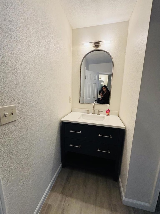 bathroom with vanity, wood-type flooring, and a textured ceiling