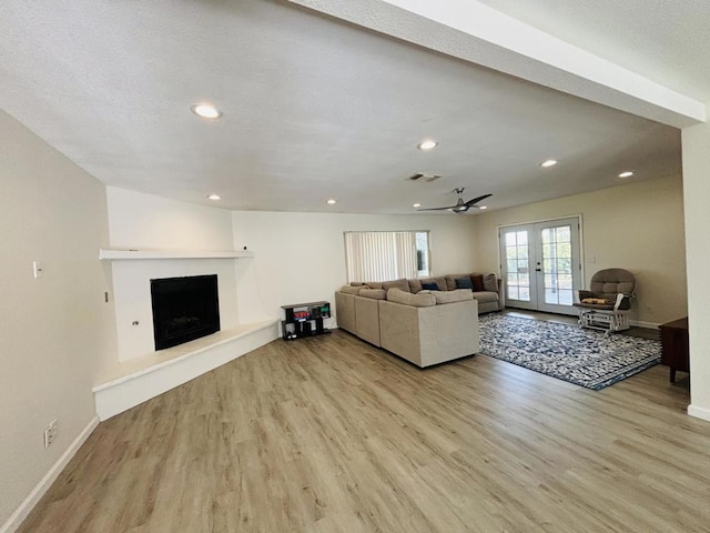 living room featuring french doors, light hardwood / wood-style floors, and ceiling fan