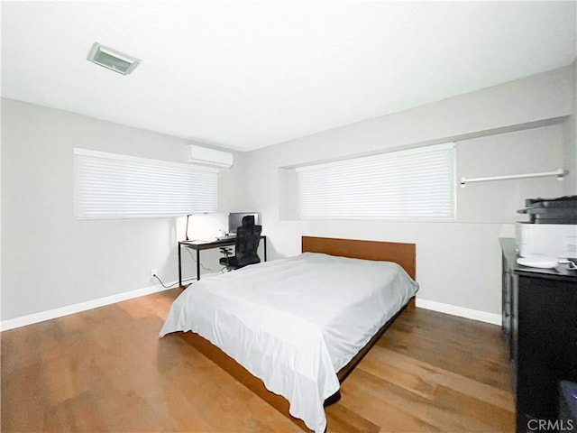 bedroom featuring a wall mounted AC and wood-type flooring