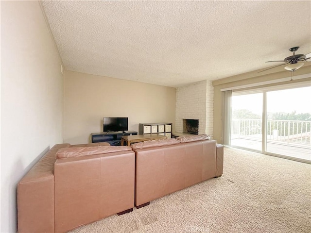 living room featuring a textured ceiling, light colored carpet, a brick fireplace, and ceiling fan