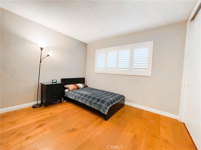 bedroom with hardwood / wood-style floors and a textured ceiling