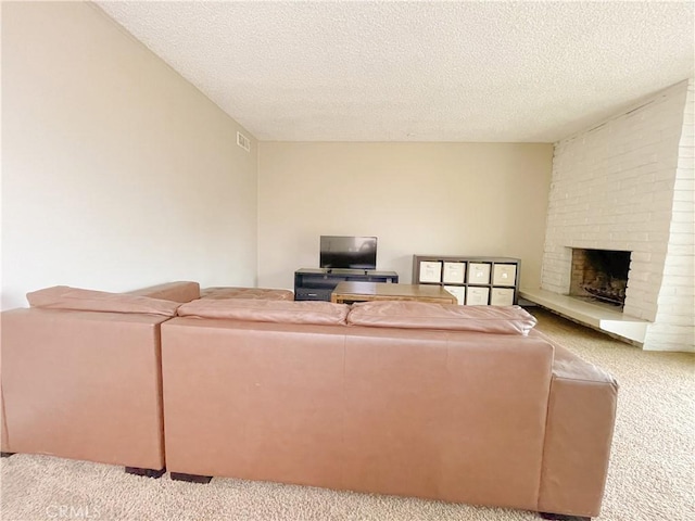 carpeted living room featuring a fireplace and a textured ceiling