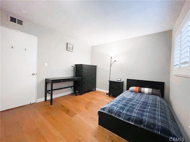 bedroom featuring a textured ceiling and hardwood / wood-style flooring