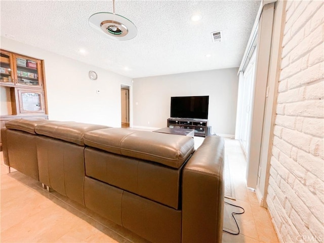 living room featuring light wood-type flooring and a textured ceiling