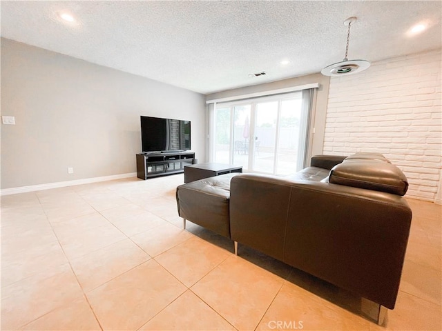 tiled living room featuring a textured ceiling