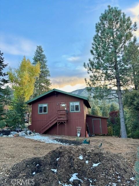 back house at dusk with a storage shed