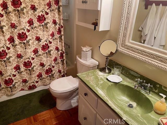 bathroom featuring vanity, toilet, and parquet floors