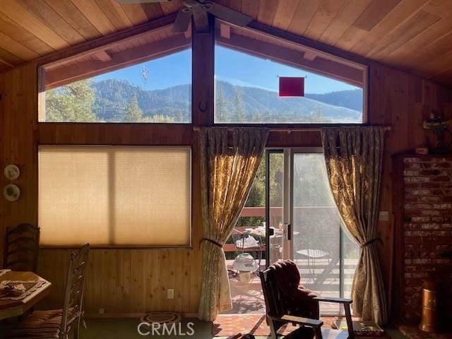 interior space featuring a mountain view, ceiling fan, wood ceiling, and lofted ceiling