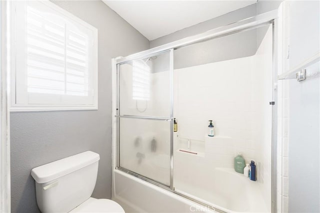 bathroom with shower / bath combination with glass door and toilet