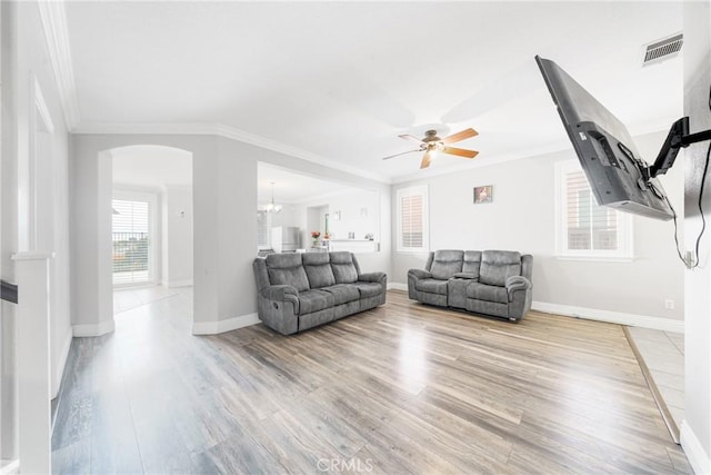 living room featuring ceiling fan, crown molding, and light hardwood / wood-style flooring