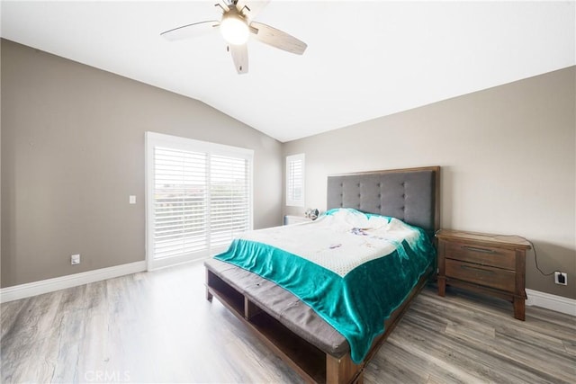 bedroom with ceiling fan, hardwood / wood-style floors, and vaulted ceiling