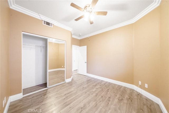 unfurnished bedroom with a closet, ornamental molding, ceiling fan, and light hardwood / wood-style floors