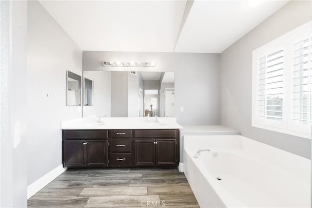 bathroom featuring wood-type flooring, vanity, and a bathtub