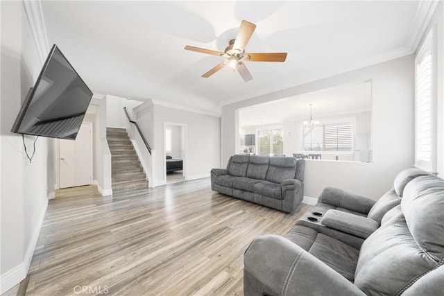 living room featuring ceiling fan with notable chandelier, crown molding, and light hardwood / wood-style flooring