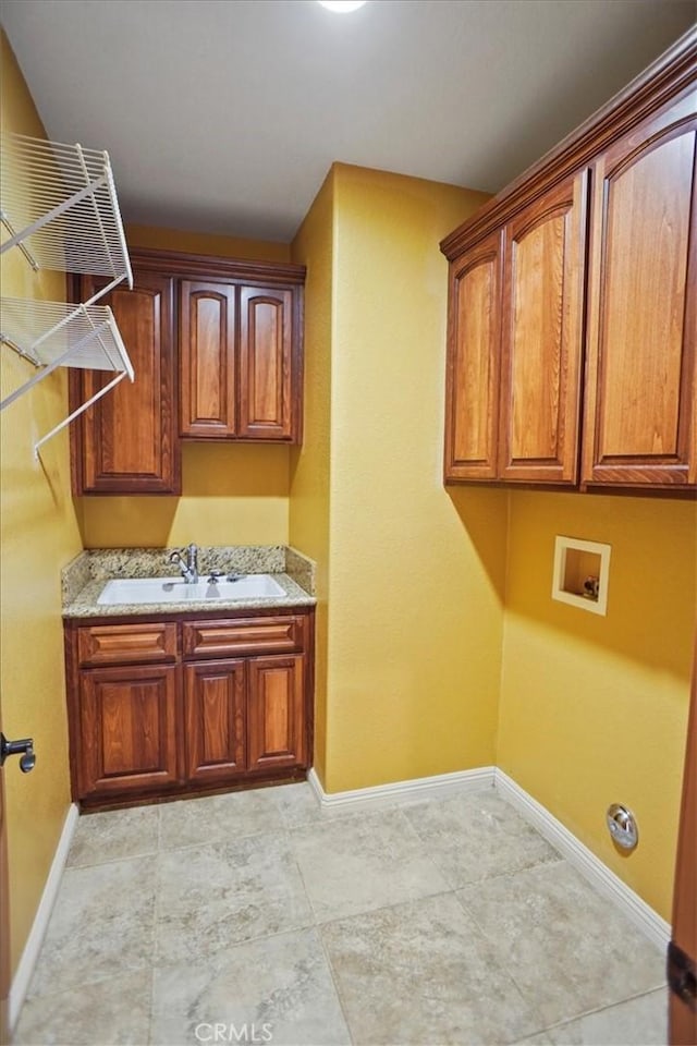 washroom featuring washer hookup, cabinets, and sink