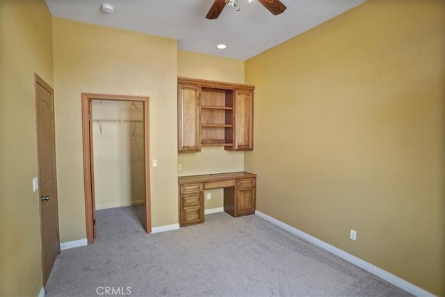 unfurnished office featuring ceiling fan and light carpet